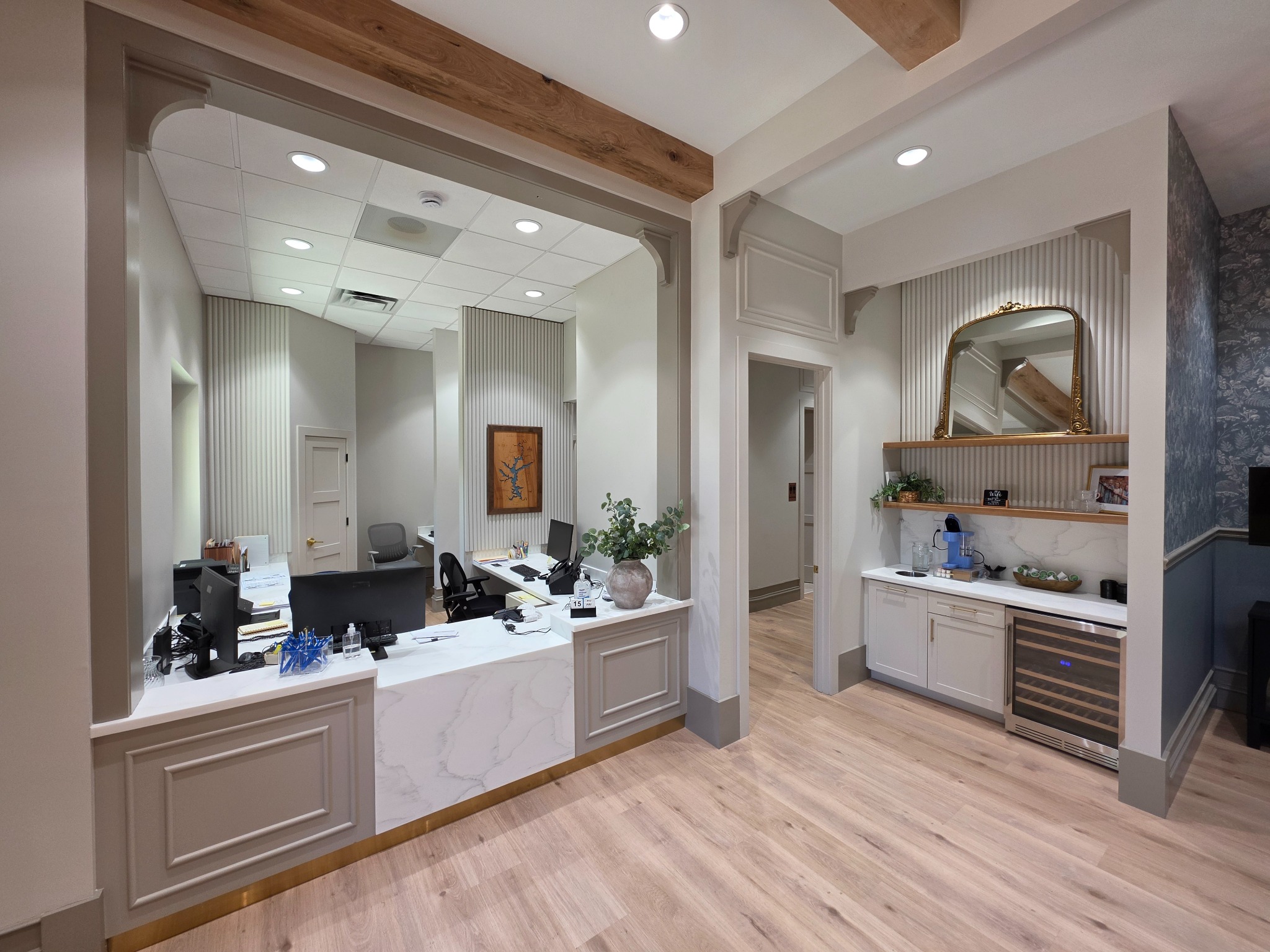 High end commercial reception with custom paneled desk and built-in cabinetry